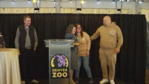 ORPC Executive Director, Melissa Michaelis Thompson, Esq. presents an award to Reunification Heroes: Brittany and Nate Bustamante during Reunification Awareness Month event at the Denver Zoo